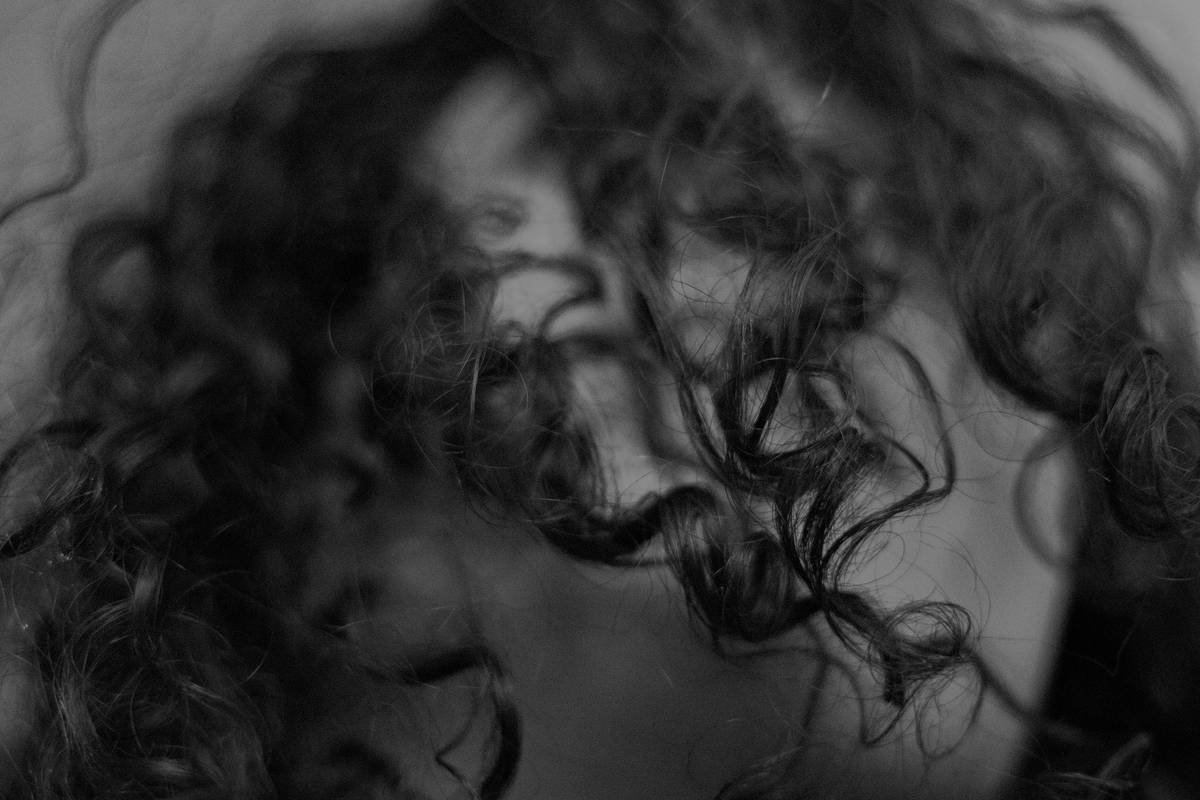 Before and after photos of Sarah's perm: left shows frizzy, undefined curls; right shows shiny, bouncy spiral curls after 10-day care routine